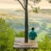 man sitting on platform enjoying a view of nature