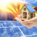 The concept of renewable energy with a house in the hands against the background of the flag of Arizona and solar panels.