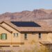 House with solar panels on roof and blue sky in background, Nevada, USA